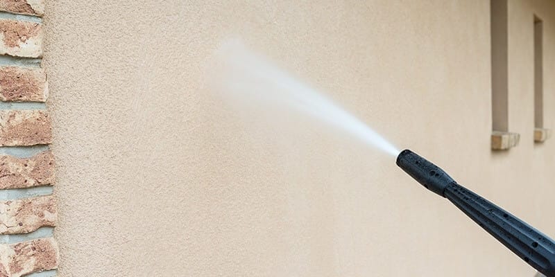 Pressure washing stucco to clean it before painting acrylic stucco.